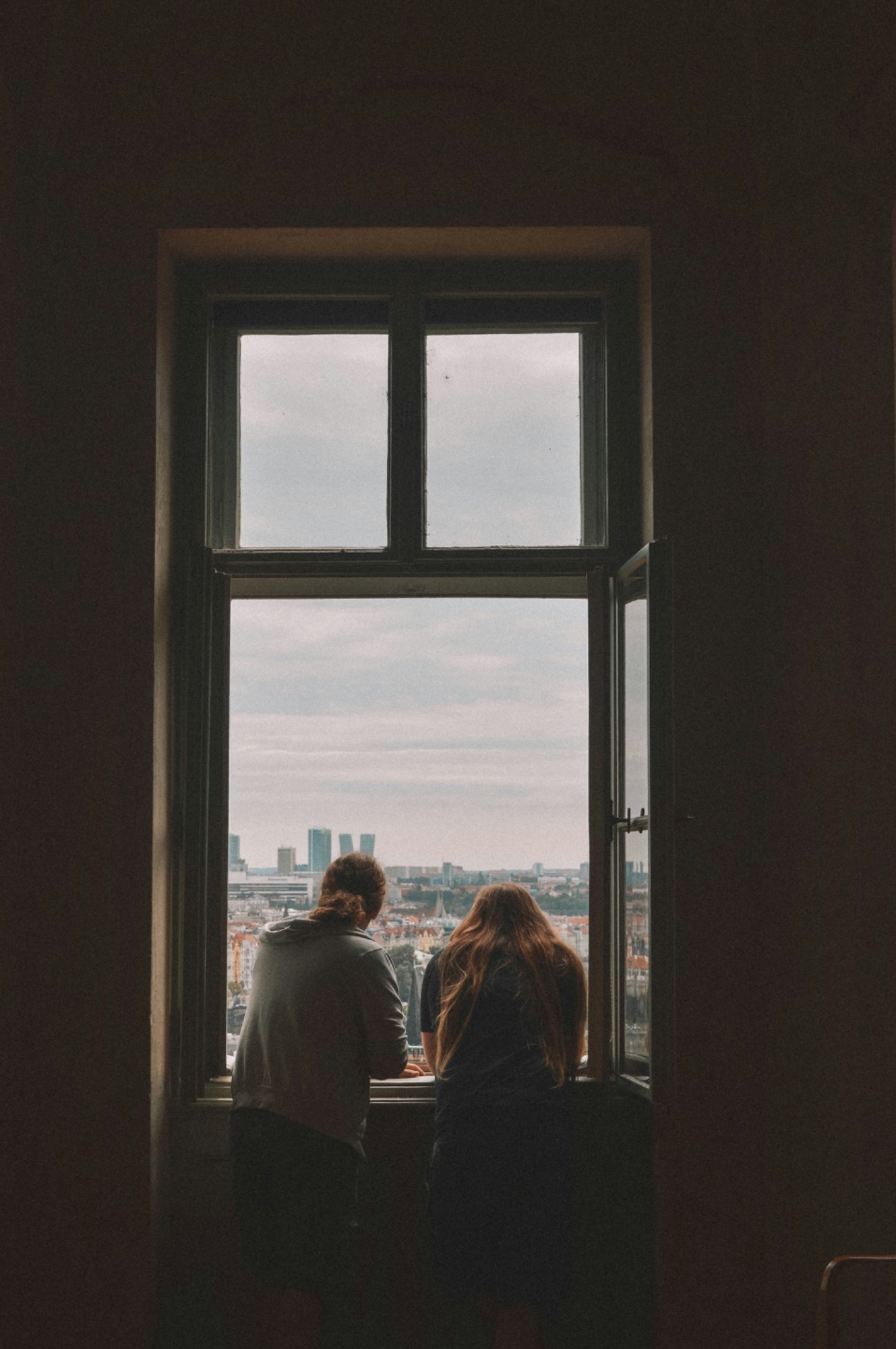 Couple sitting together at a window, processing difficult emotions