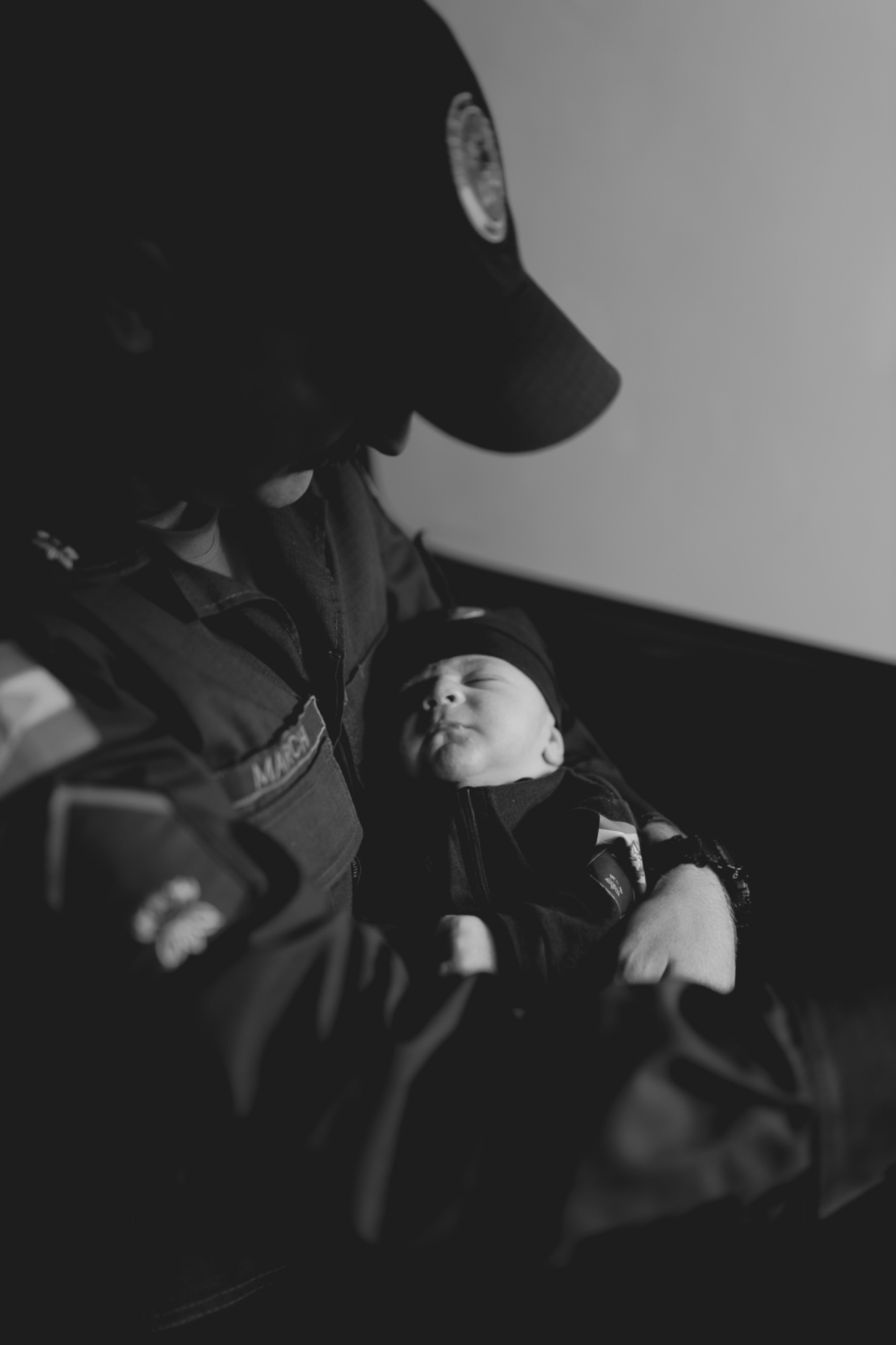 First responder in uniform cradling a newborn